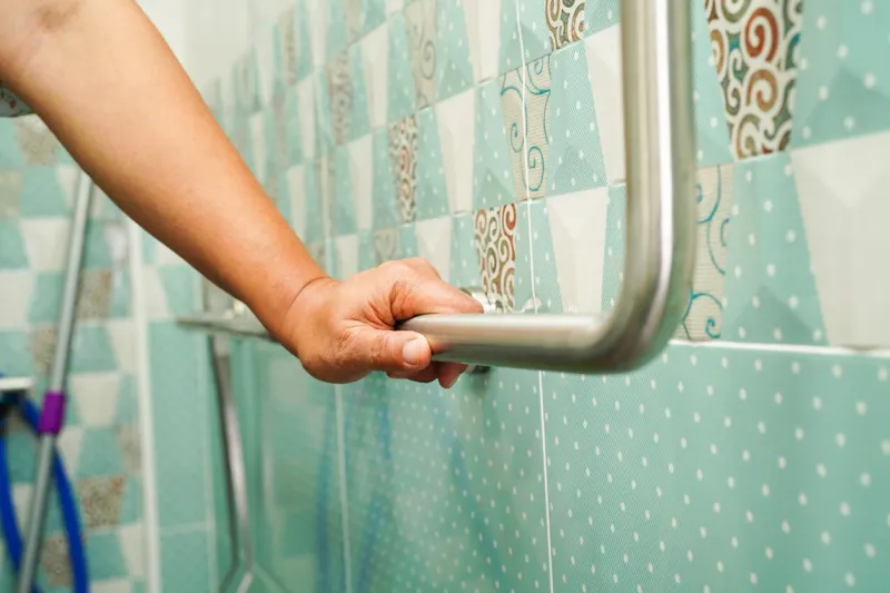 asian woman patient use toilet support rail in bathroom, handrail safety grab bar, security in nursing hospital