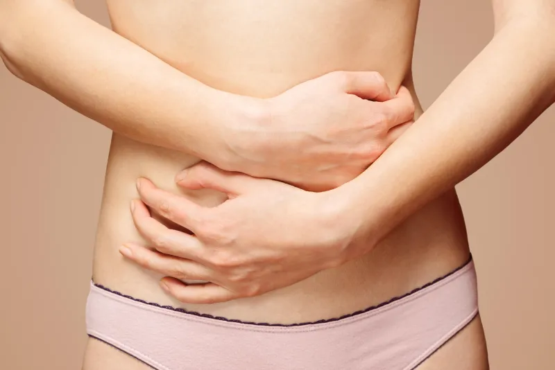femme méconnaissable tient son abdomen, vue de face, douleur abdominale ou menstruelle