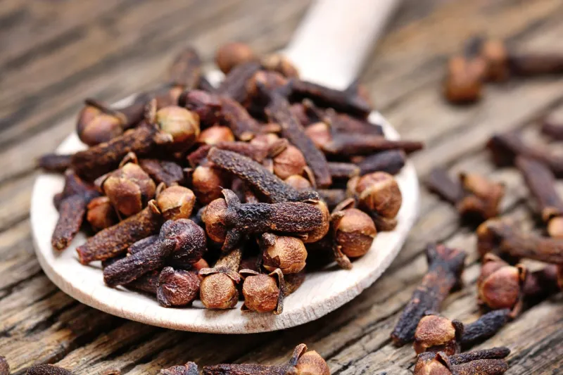 close up of clove in a wooden spoon on old table