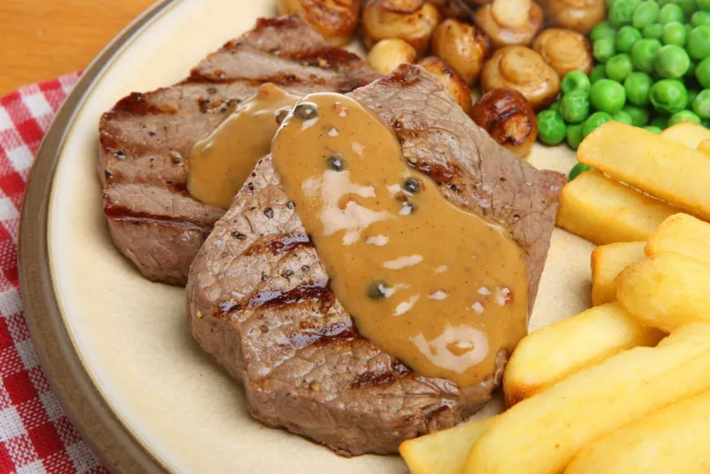 rump steaks with peppcorn sauce, mushrooms, chips and peas