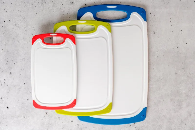 set of plastic cutting boards in different colors and sizes close-up from above with copy space