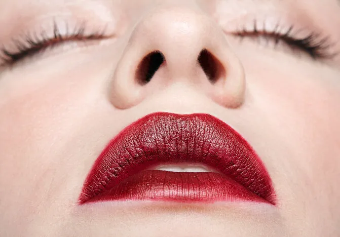 closeup macro portrait of female part of face human woman with red lips and beauty makeup eyes closed