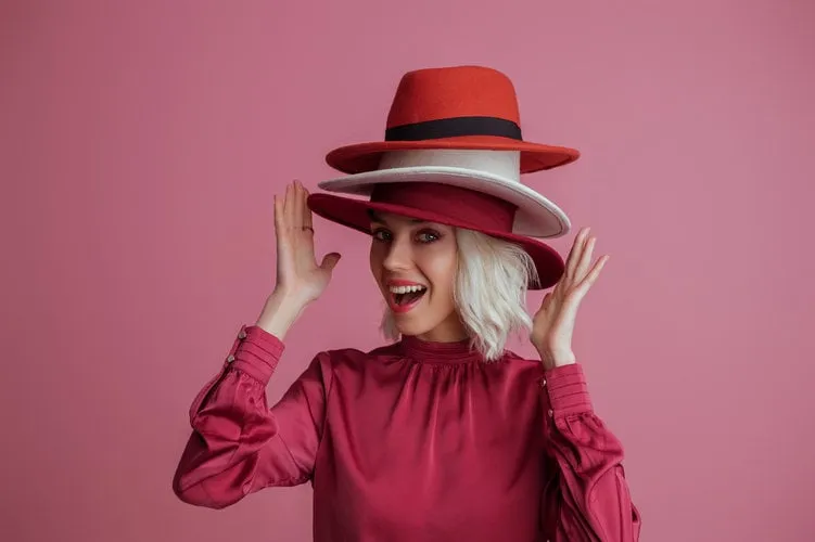 funny, happy smiling fashionable woman wearing many hats, posin