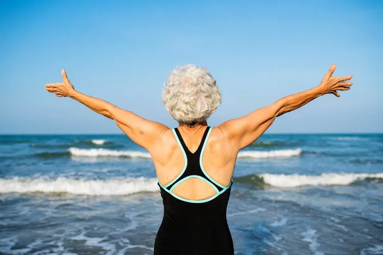 mature woman feeling free at the beach