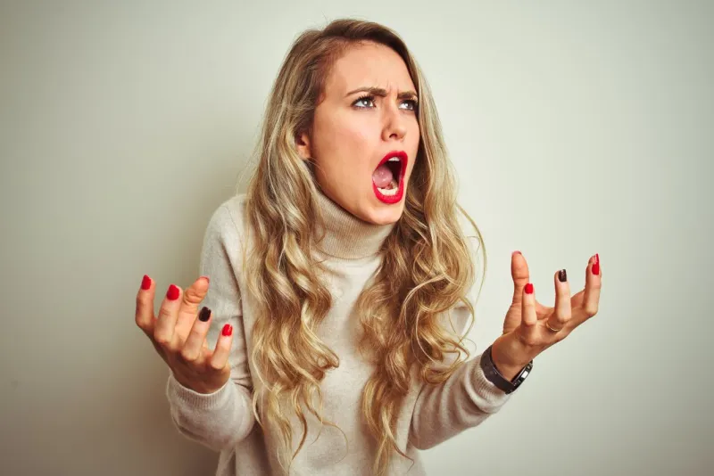 beautiful woman wearing winter turtleneck sweater over isolated white background crazy and mad shouting and yelling with aggressive expression and arms raised frustration concept