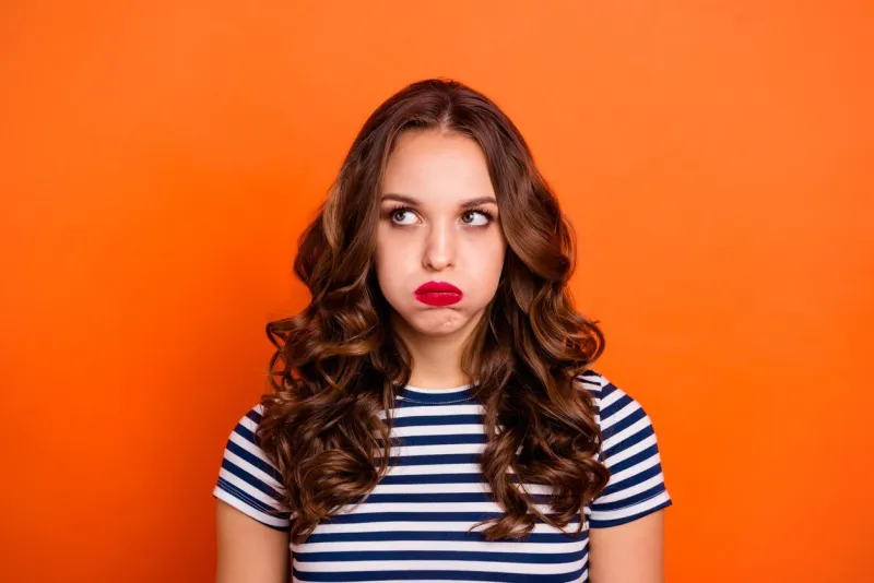 close up photo beautiful she her lady red lipstick hold breath full mouth air ignore not listen speak talk tell look up wear casual striped white blue t-shirt clothes isolated orange bright background