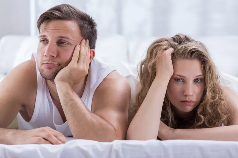 young bored couple having problems in bedroom