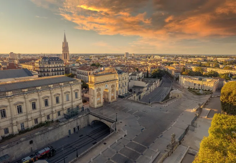 aerial view of the porte du peyrou and montpellier city at sunrise, france
