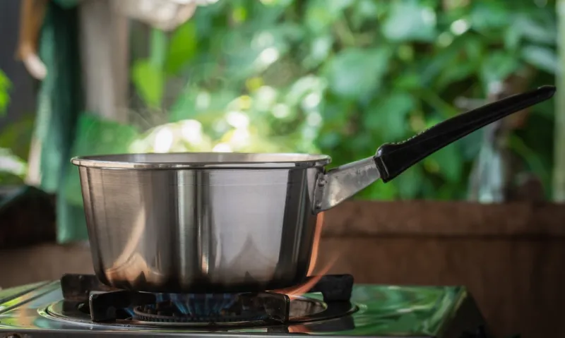 steel pot on the gas stove with burning in kitchen