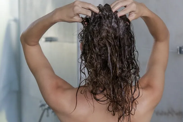 hair shampooing and scalp massage back view of woman in the shower cabin