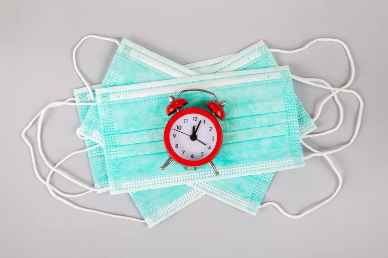 disposable mask against coronavirus 2019-ncov droplet infection and an antibiotic syringe it lies on a gray background