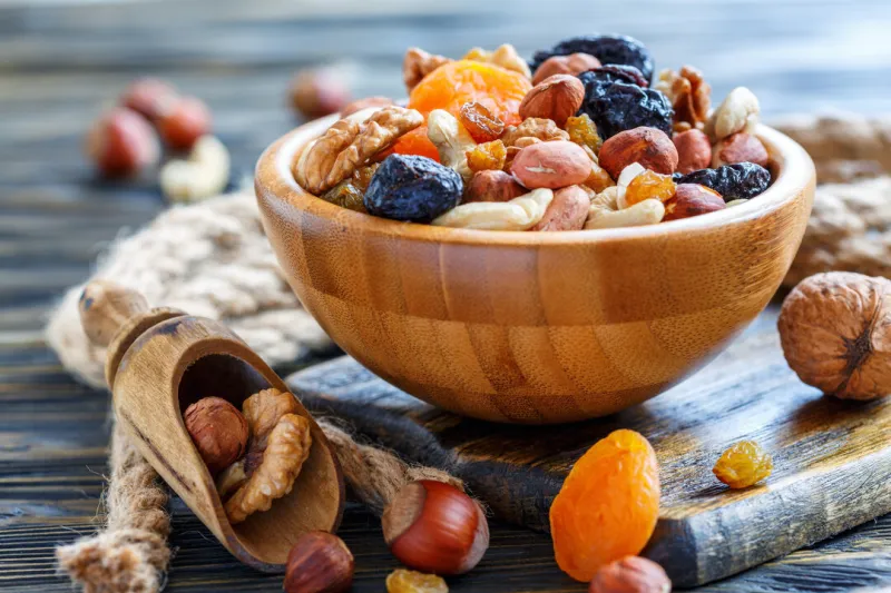 bowl of nuts and dried fruits and wooden scoop on the old table