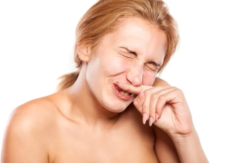 beautiful blonde without makeup frowns due to allergies