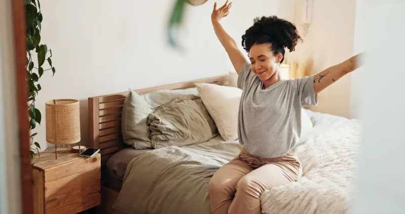 happy woman, wake up and stretching in bedroom or morning for rest, relax and comfort in home female person, peace and zen on weekend for calm, rest and wellness as positive, fresh and cozy in house