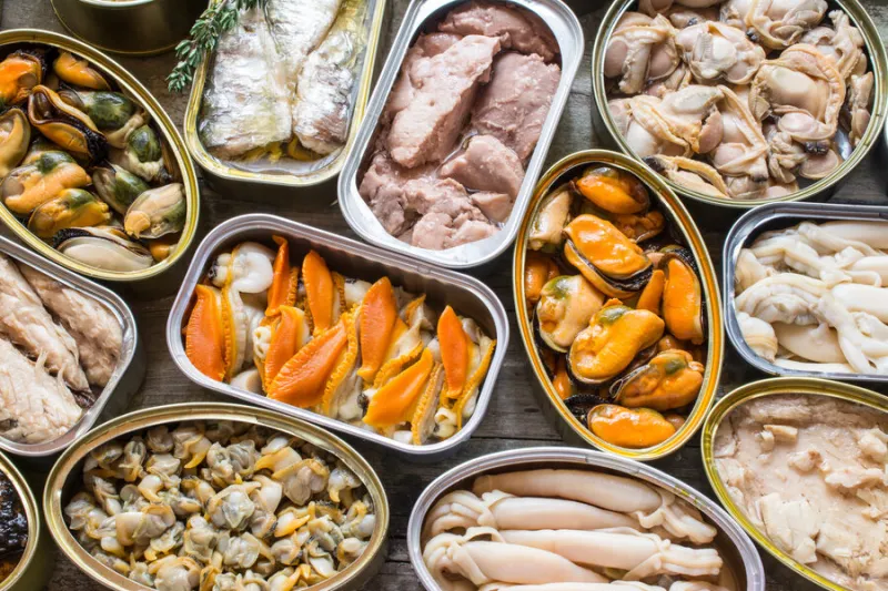 assortment of cans of canned with different types of fish and seafood
