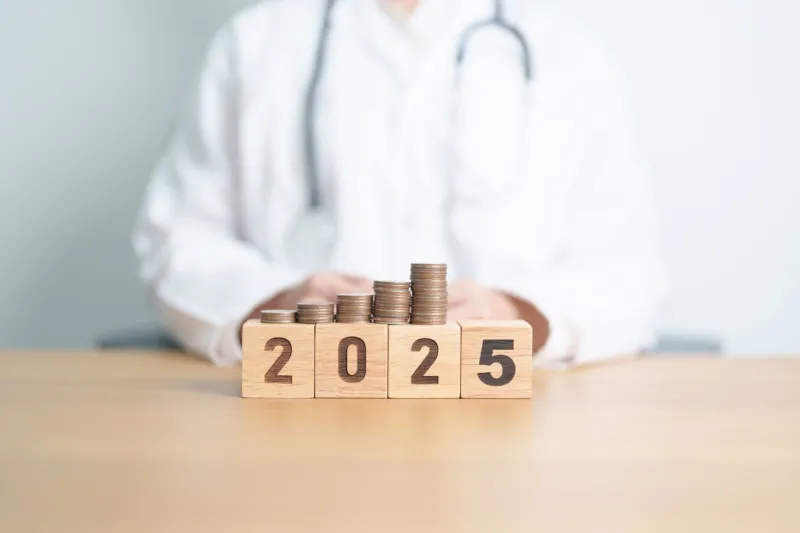happy new year 2025 with doctor and coins stack money stack counting arrangement for deposit, healthcare cost, money saving, health insurance, medical, donation and financial concept