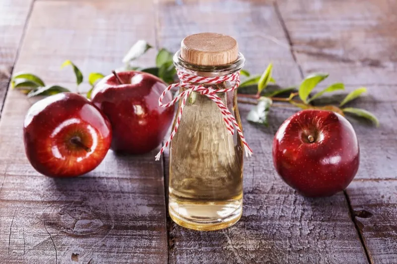 vinaigre de cidre de pomme et pommes rouges sur fond en bois rustique