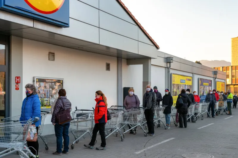 ruzomberok, slovakia - april 2  long line of people with face masks and shopping cart in front of grocery