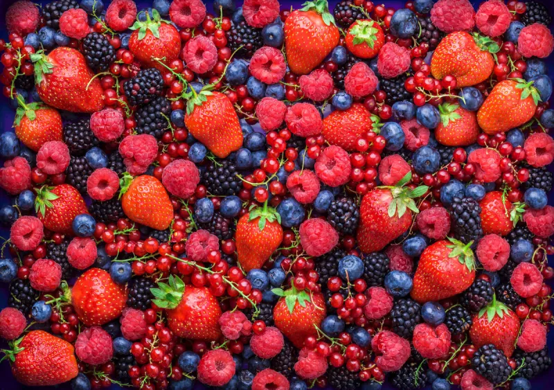 berries overhead closeup colorful assorted mix of strawbwerry, blueberry, raspberry, blackberry, red curant in studio on dark background