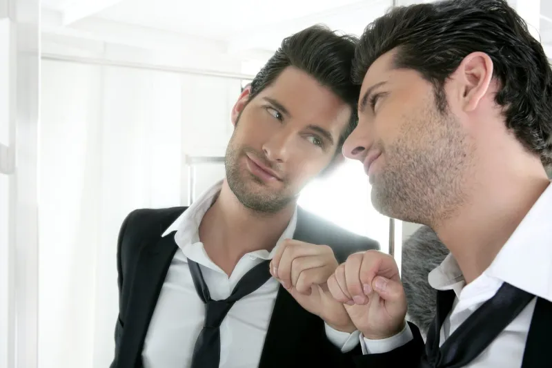 handsome narcissistic suit proud young man looking himself in the mirror