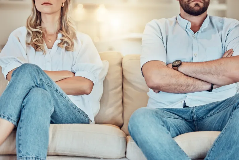 unknown couple fighting and giving each other the silent treatment caucasian man and woman sitting on the sofa with their arms folded after an argument unhappy husband and wife ignoring each other