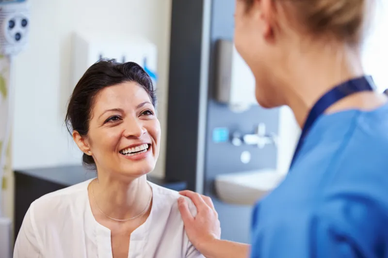 female patient being reassured by doctor in hospital room