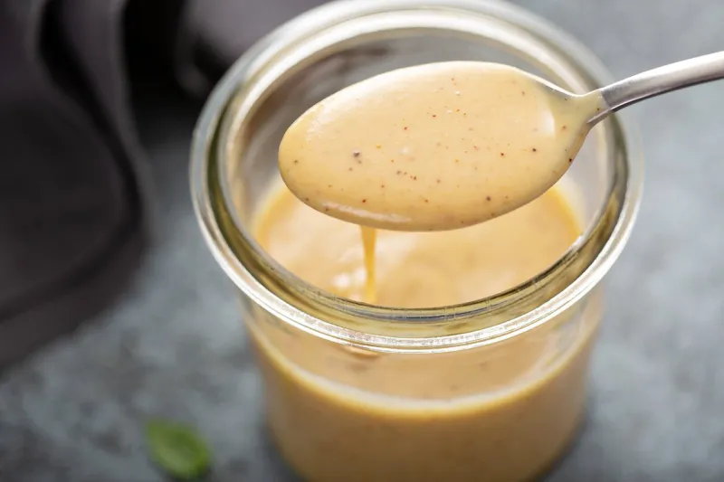 homemade creamy honey mustard sauce in a glass jar