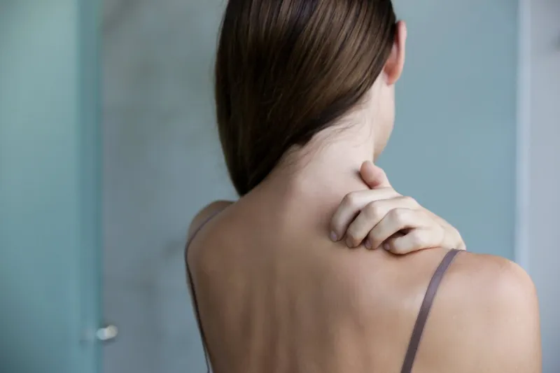 close up view of woman scratching her neck