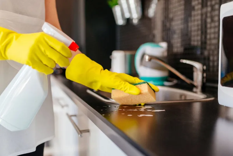 woman cleaning kitchen cabinets with sponge and spray cleaner more from this series in my portfolio