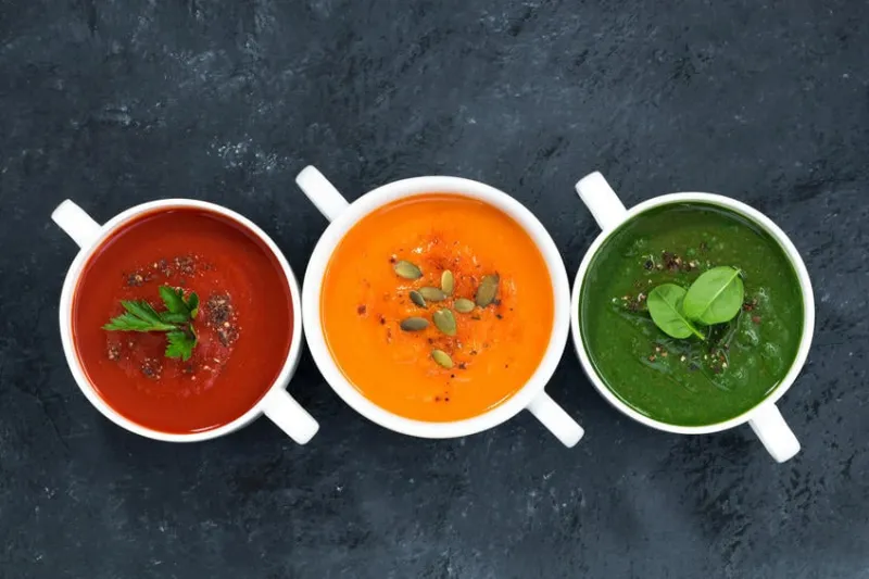 assortiment de soupe de légumes frais sur un fond sombre, vue de dessus