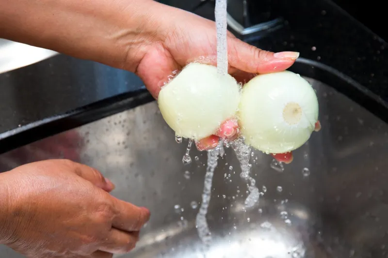 peeled onion under running water