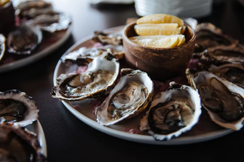 fresh oysters on plate, served table with oysters, lemon in restaurant gourmet food