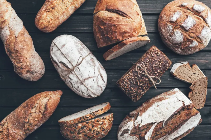 delicious freshly baked bread on wooden background