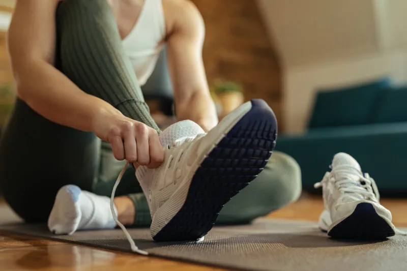 close-up of athletic woman putting on sneakers