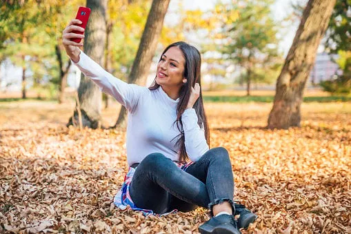 young beautiful woman making selfies in autumn park