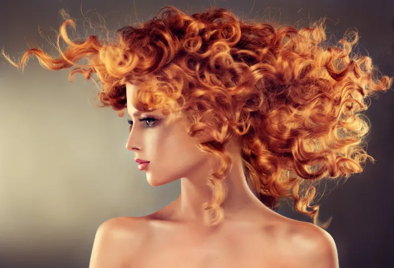 pretty red haired girl with curly hairstyleflying hair in dynamic movement
