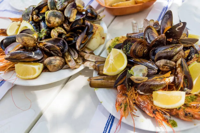 mix of spicy shrimps and shellfish cooked with parsley, garlic and lemon spanish restaurant table
