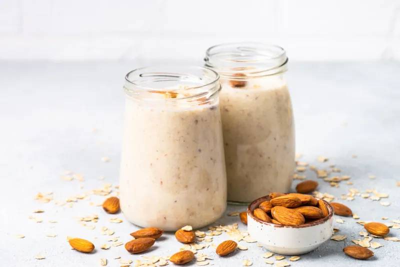 almond banana smoothie with oat flakes in glass jars