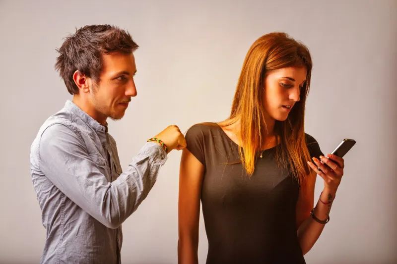 while he tries to get her attention, the woman looks intently at her phone, subtly turning it away from him this moment highlights a disconnection, with her withholding focus
