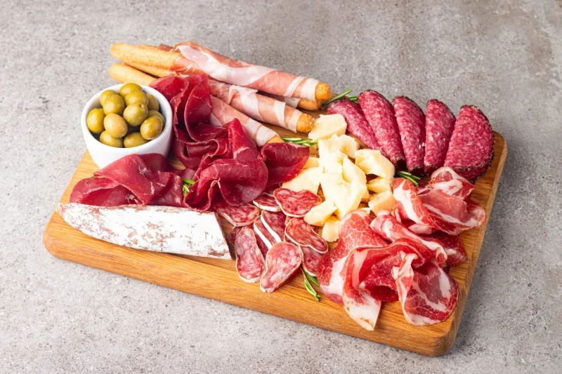 charcuterie board antipasti appetizers of meat and cheese platter with salami, prosciutto crudo or jamon and olives