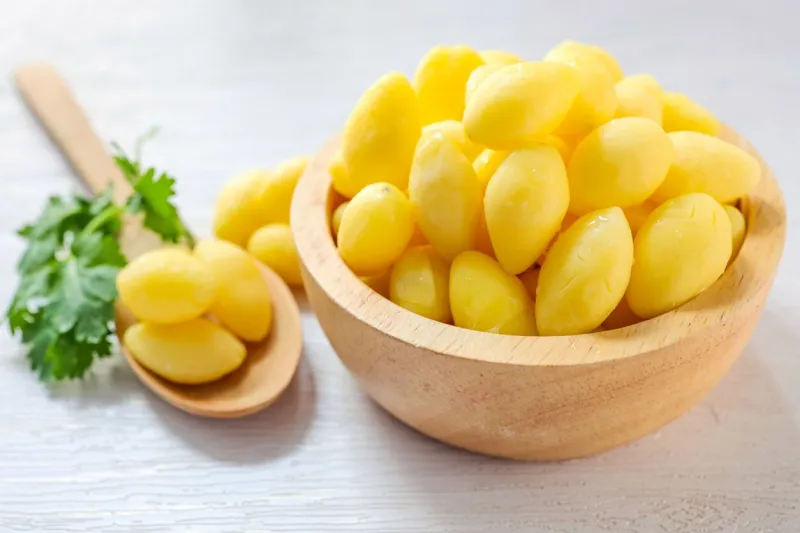 ginkgo biloba in a wooden bowl with wooden spoon on white background