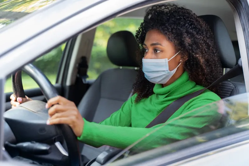 black woman reaching a drive-through test site for a quick corona test