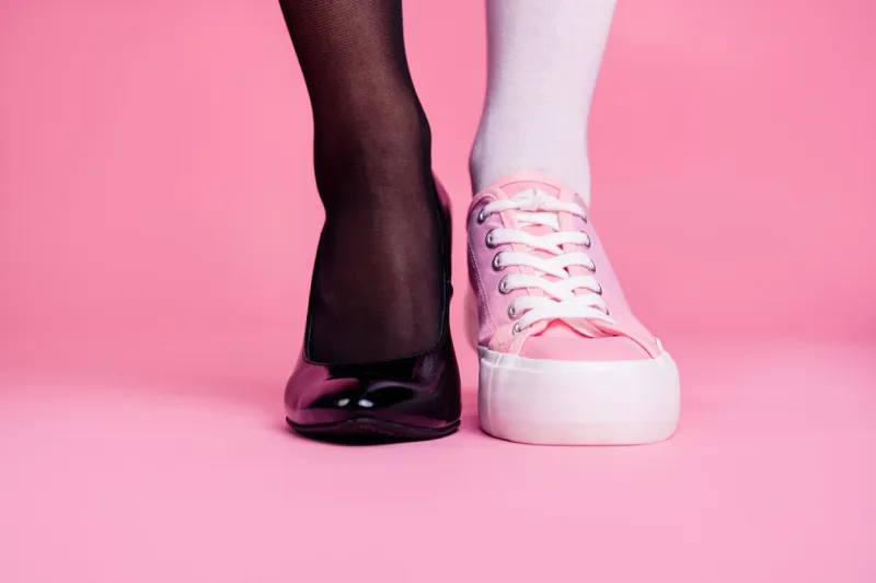 cropped close-up view image concept photo of two different fit thin slim legs cozy comfort luxury luxurious elegant chic sporty comparison footgear isolated on pink pastel background