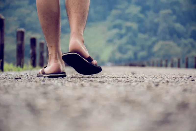 low section of man walking on street