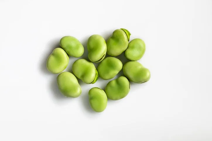 close-up top view of fresh green broad beans isolated on white background healthy food macro