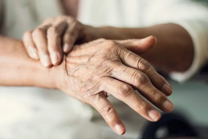 close up hands of senior elderly woman patient suffering from pakinson's desease symptom mental health and elderly care concept