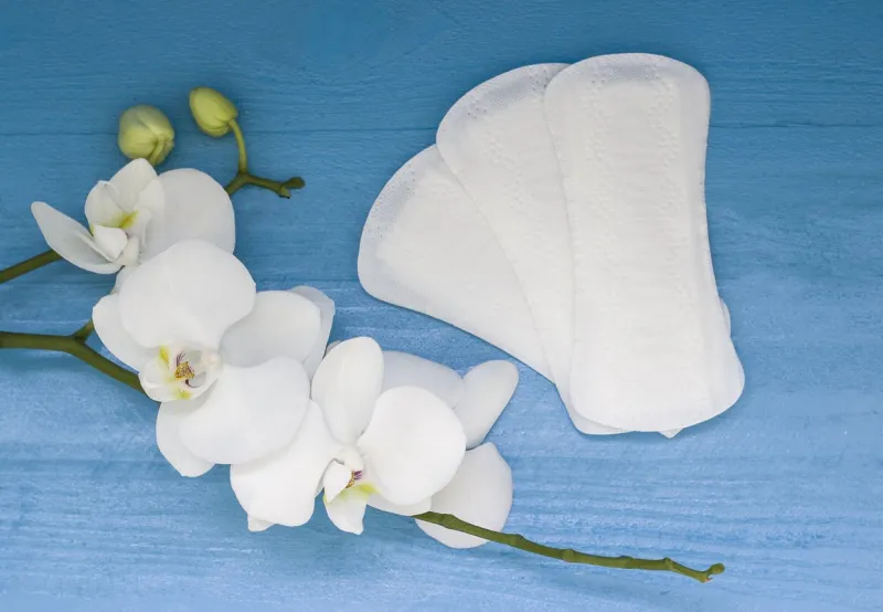 sanitary pads and lilac orchid on the blue wooden background