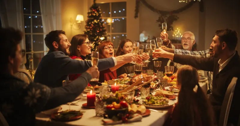 portrait of a handsome young black man proposing a toast at a christmas dinner table family and friends sharing meals, raising glasses with champagne, toasting, celebrating a winter holiday