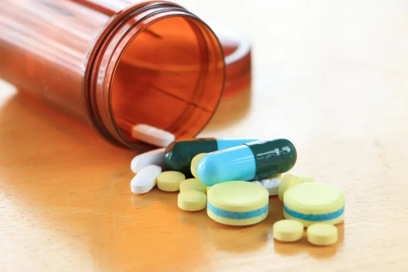 many types of medicines on a wood table refers to health care