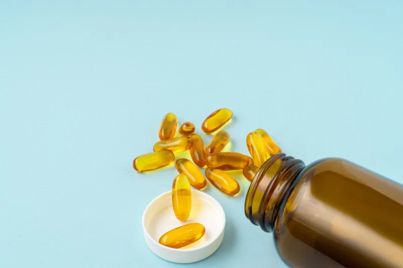 fish oil tablet on a blue background with a copy space medical and health care concept